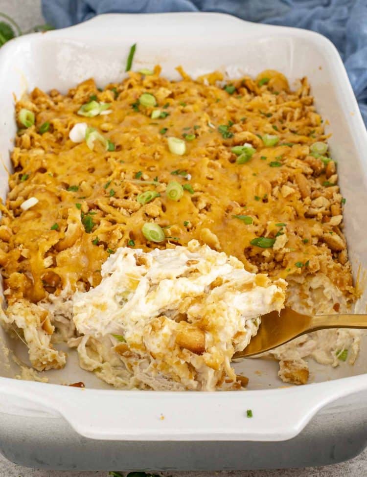 Creamy Neiman Marcus Chicken Casserole in a baking dish, showing crunchy cracker topping and soft chicken filling being served.