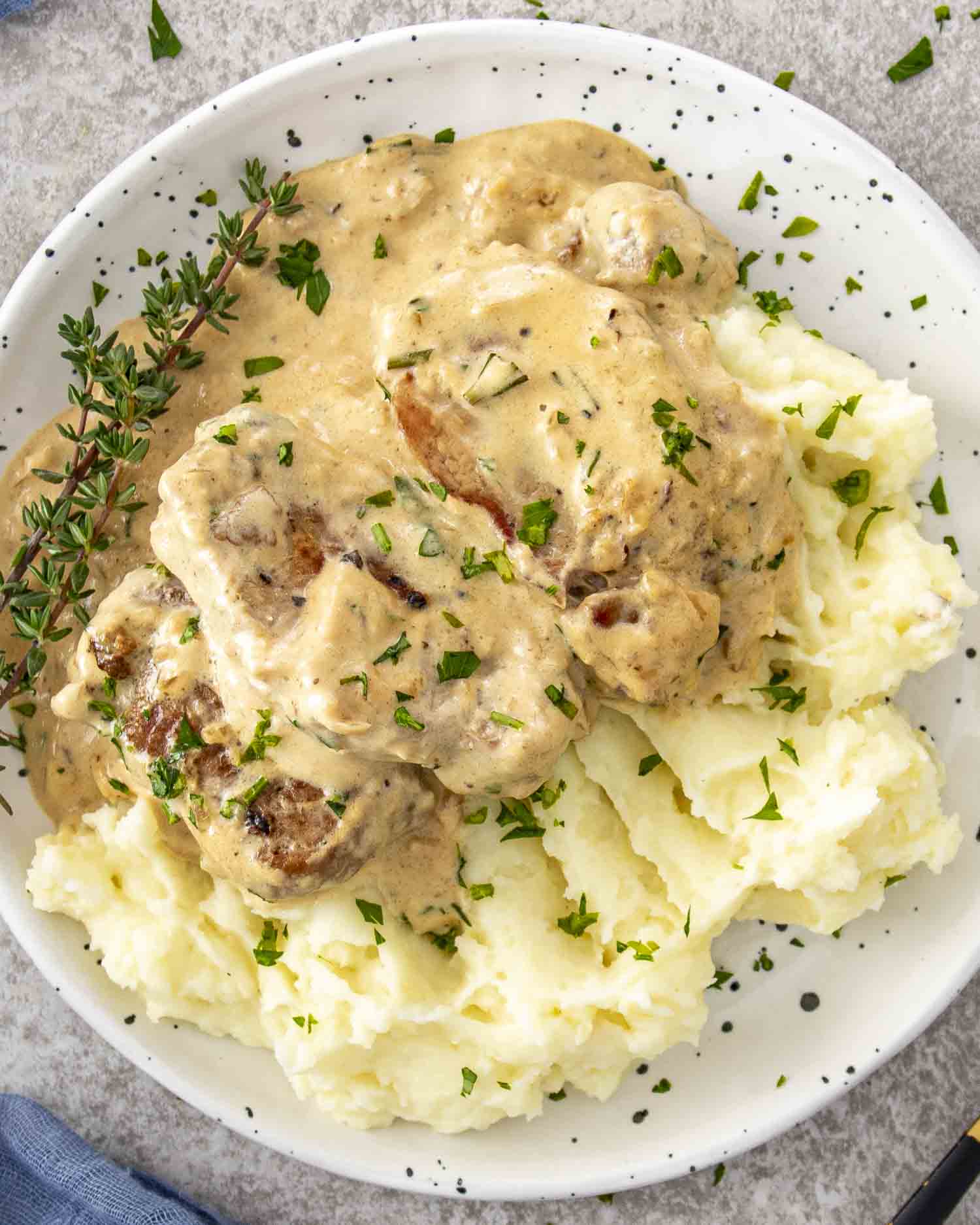 Creamy garlic pork medallions served over fluffy mashed potatoes, topped with fresh herbs and plenty of rich sauce.