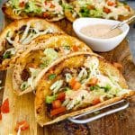 Smashed burger tacos resting in taco holder with crisp tortillas, seasoned beef, melted cheese, and classic toppings.