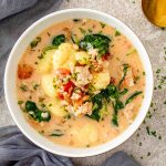 Creamy Tuscan Sausage Gnocchi Soup served in a bowl with Italian sausage, gnocchi, spinach, tomatoes, and Parmesan.