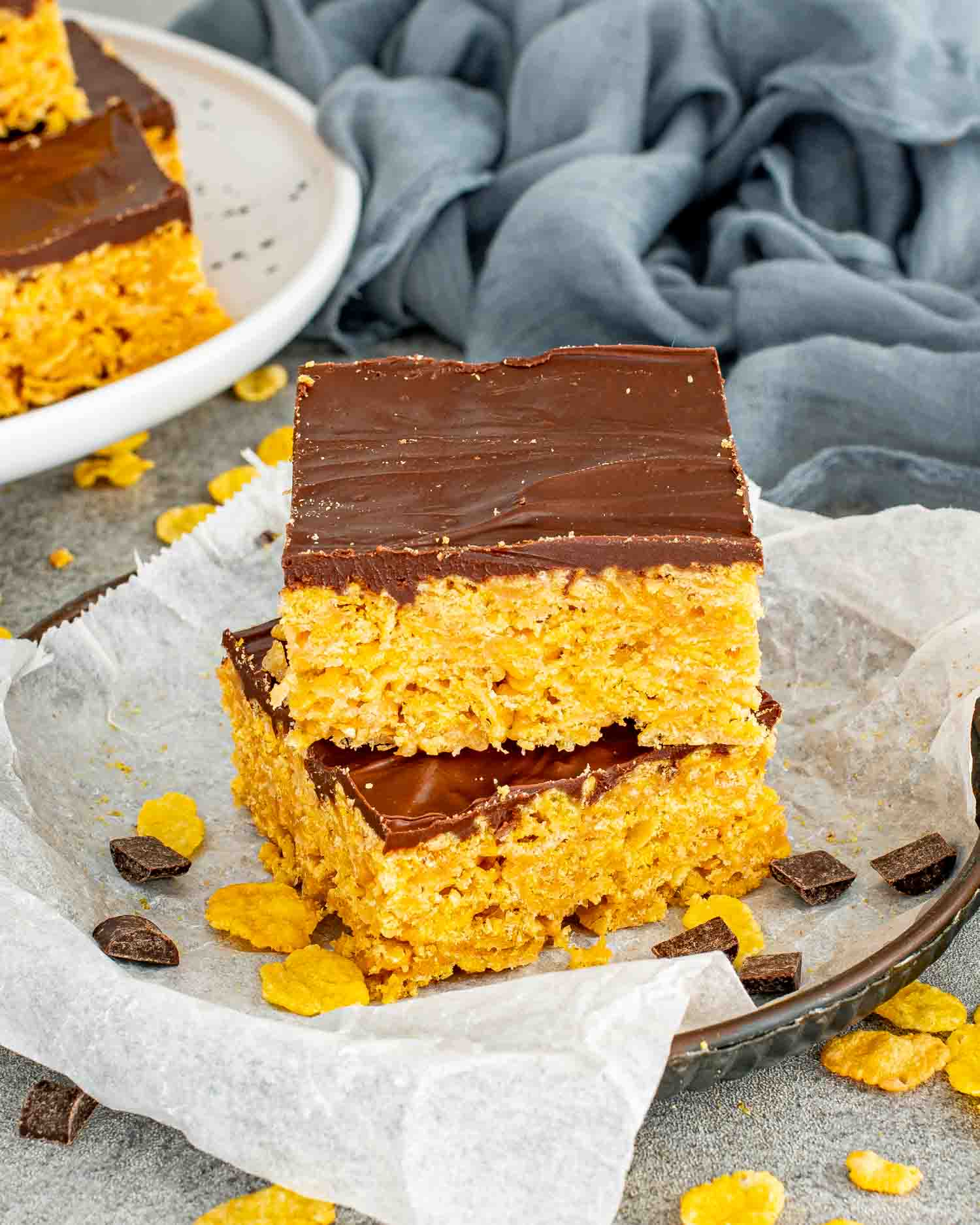 Close up of stacked no bake Butterfinger bars showing crunchy cornflake peanut butter base and smooth chocolate topping.