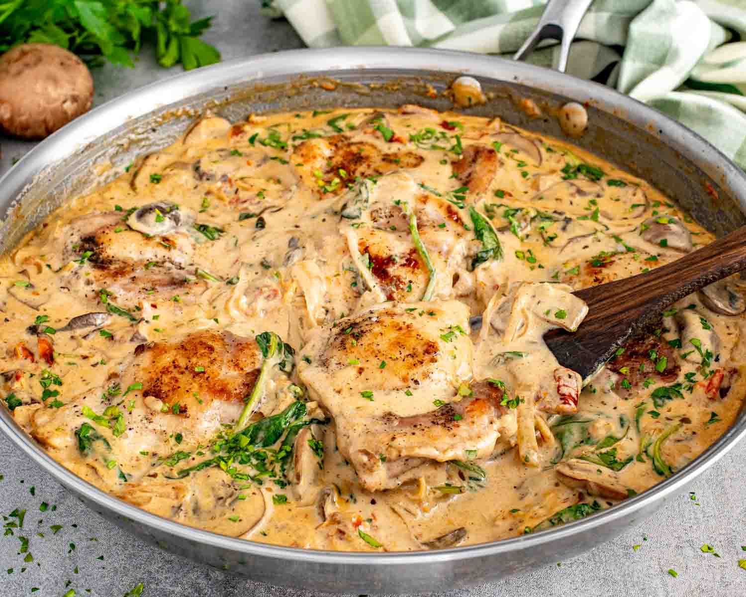 One pan creamy mushroom and sun dried tomato chicken with golden chicken thighs simmered in rich sauce with spinach and mushrooms.