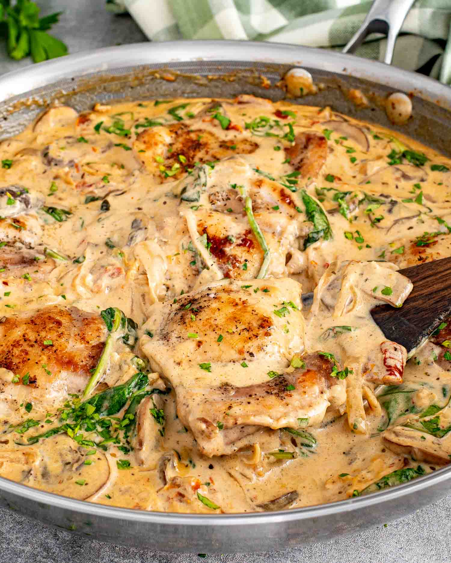 One pan creamy mushroom and sun dried tomato chicken with golden chicken thighs simmered in rich sauce with spinach and mushrooms.