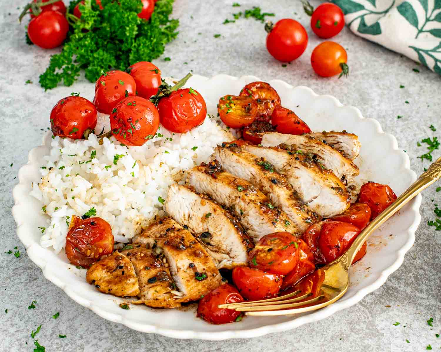 Sliced balsamic chicken breast served with fluffy rice, roasted cherry tomatoes, and glossy garlic balsamic pan sauce on plate.