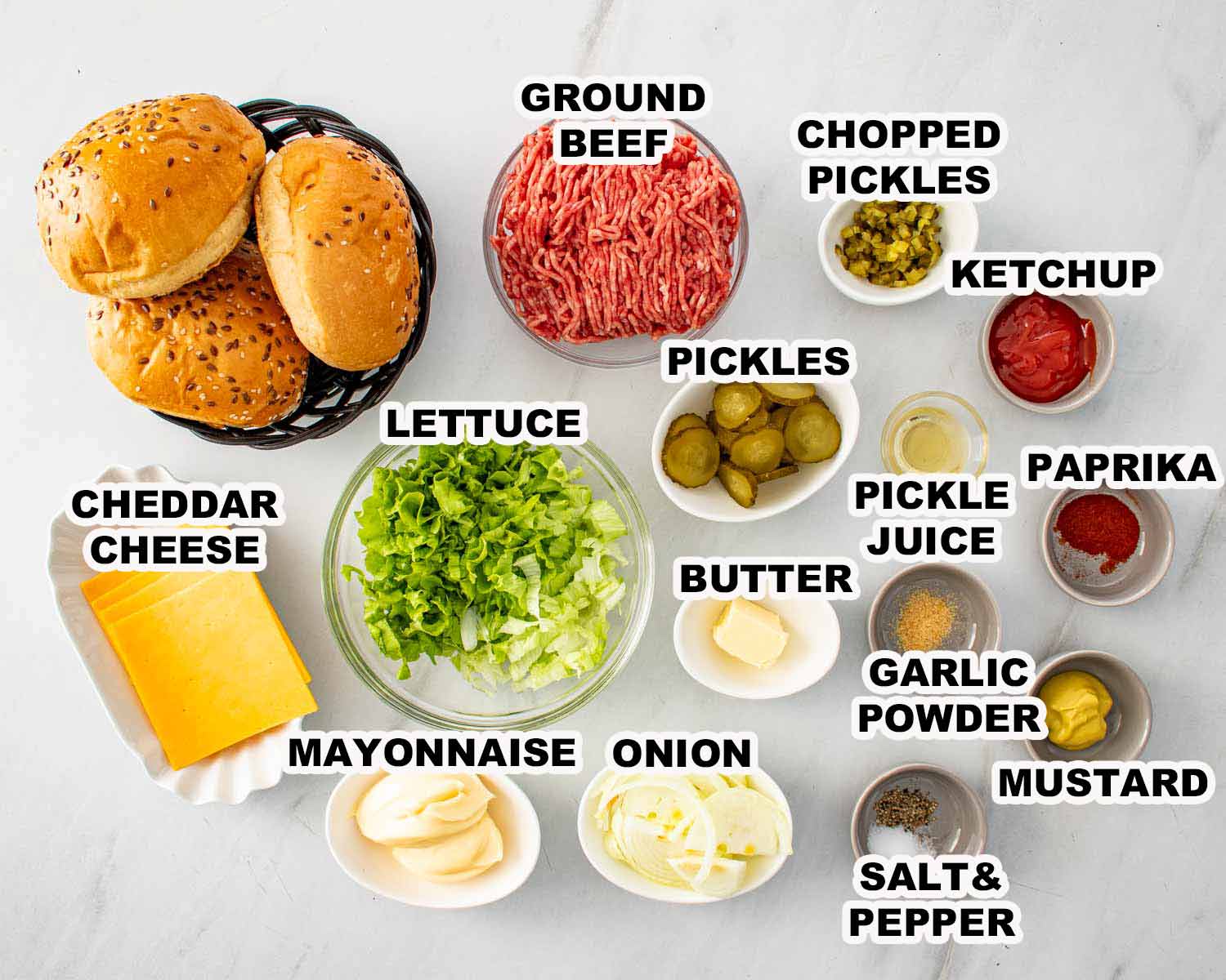 Overhead flat lay of smashed burger ingredients including ground beef, cheddar cheese, burger buns, lettuce, pickles, onion, mayonnaise, ketchup, mustard, butter, pickle juice, paprika, garlic powder, salt, and pepper.