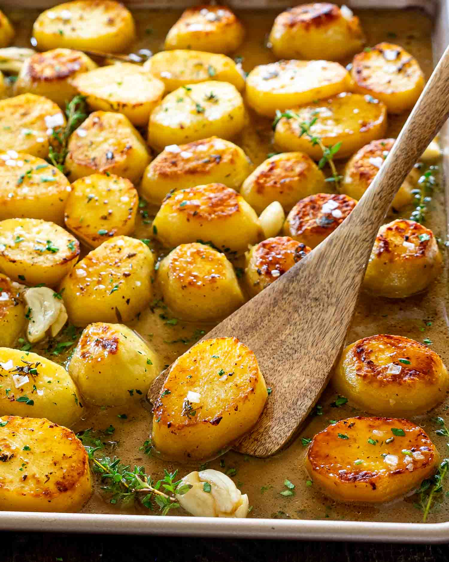 Golden melting potatoes roasted until crisp outside and creamy inside, nestled in buttery broth with garlic, thyme, and flaky salt.