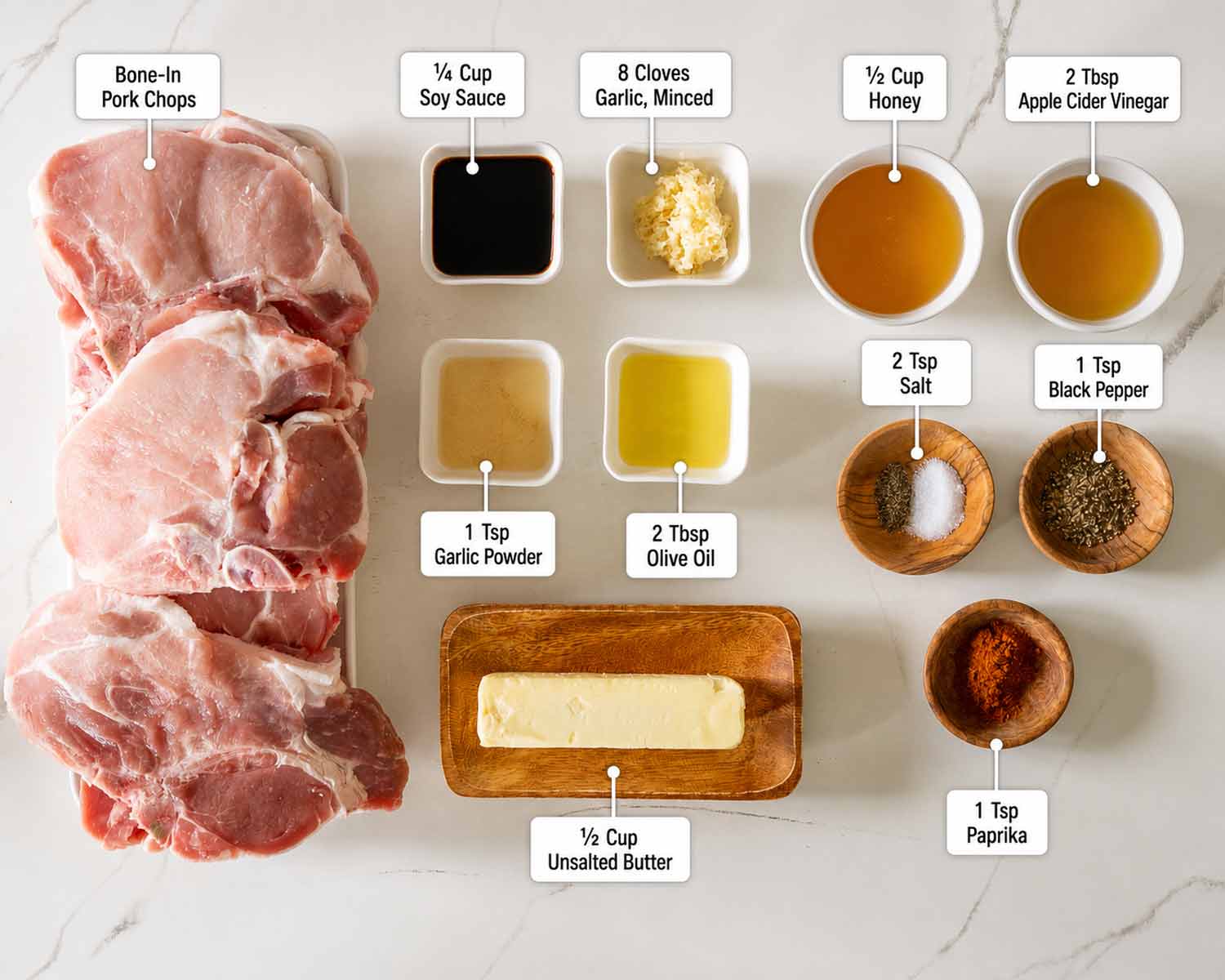 Overhead ingredient photo showing pork chops, honey, garlic, soy sauce, butter, seasonings, olive oil, and vinegar.