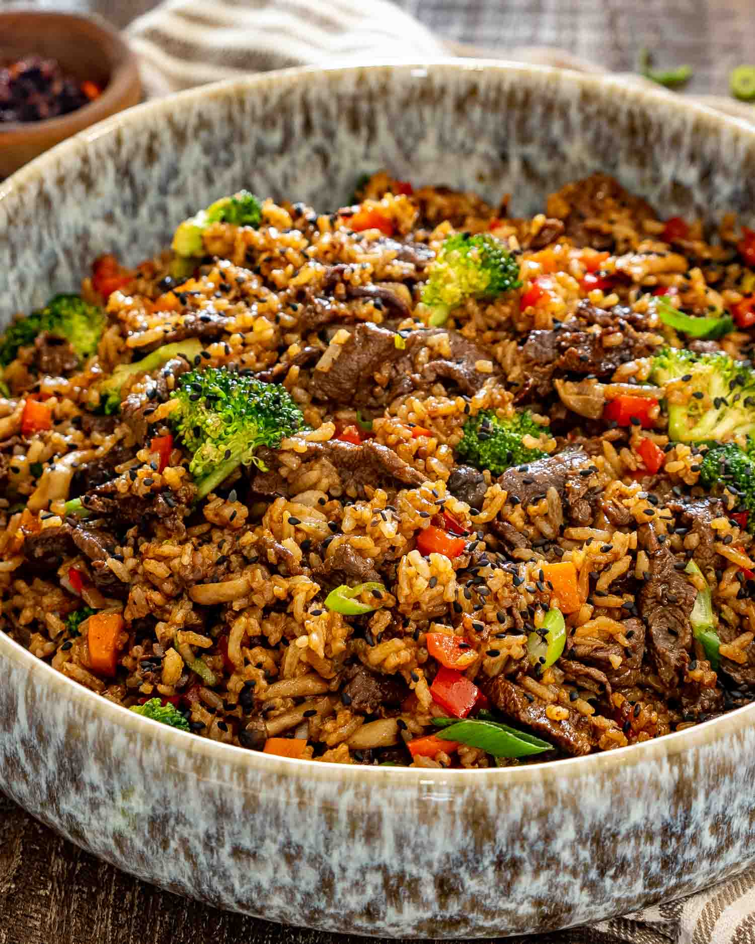 Close-up of sticky beef fried rice packed with tender beef, crisp broccoli, mushrooms, peppers, carrots, and savory seasoned rice.