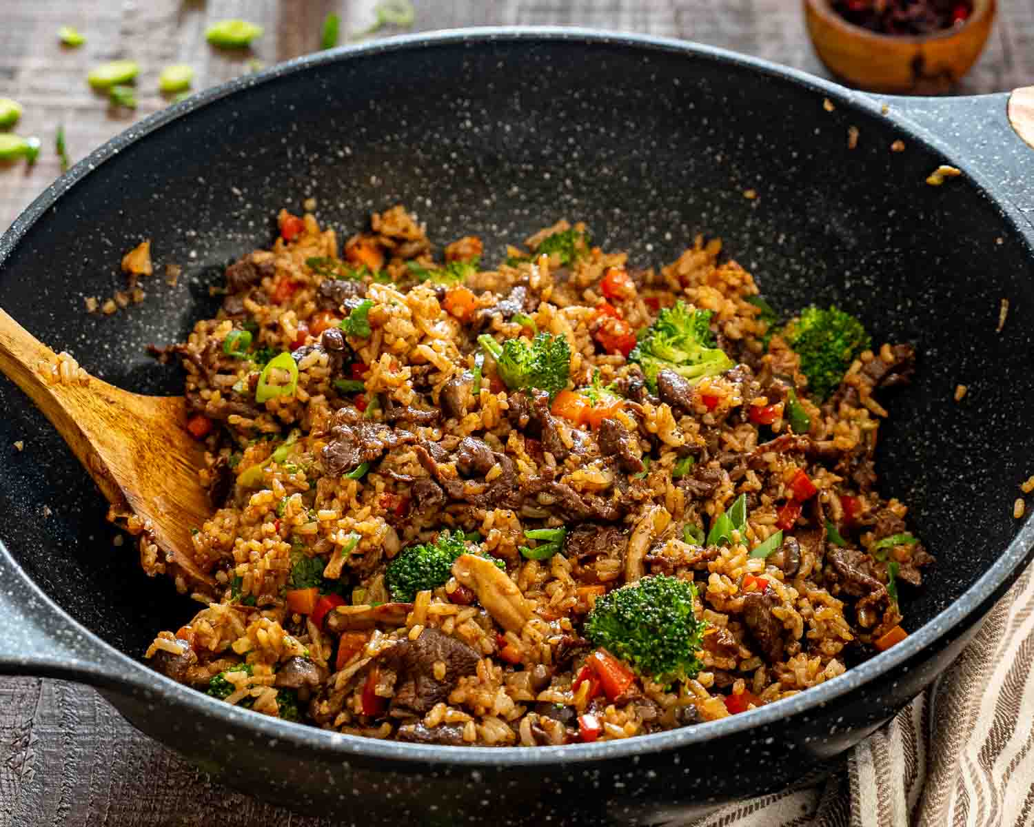 Close-up of sticky beef fried rice in a skillet with juicy beef, colorful vegetables, mushrooms, broccoli, and perfectly seasoned fluffy rice.