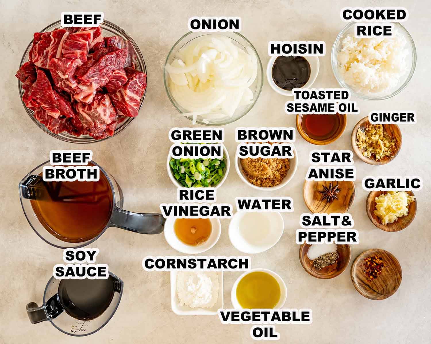 Labeled ingredients for slow cooker Asian braised beef arranged in bowls and measuring cups on a light countertop. (