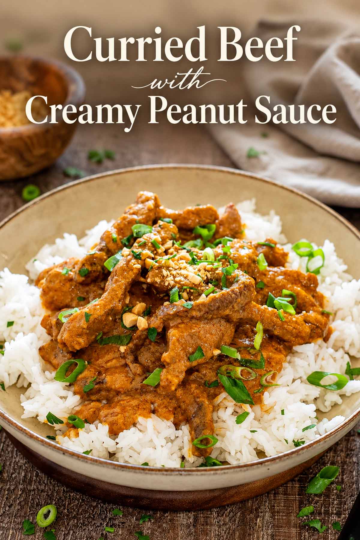 Pinterest graphic featuring curried beef with creamy peanut sauce over rice, garnished with chopped peanuts and green onions.
