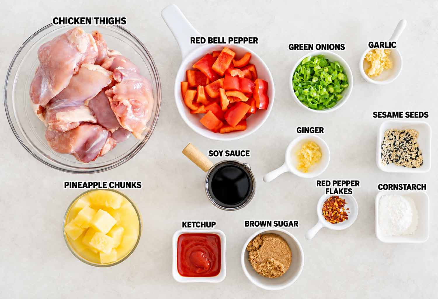 Labeled ingredients for slow cooker Hawaiian chicken include chicken thighs, pineapple, peppers, soy sauce, seasonings, ketchup, and brown sugar.